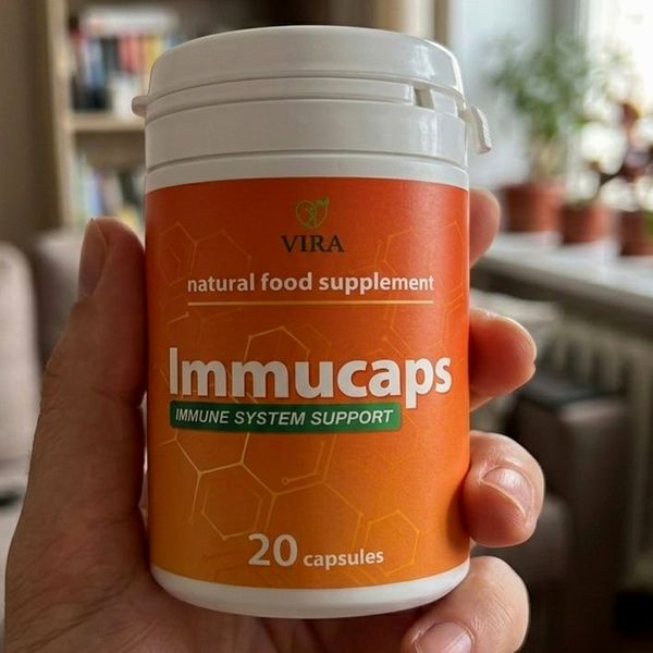 Barattolo arancione di Immucaps da 20 capsule tenuto in mano