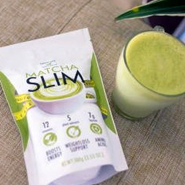 Busta bianca e verde di Matcha Slim da 100 g accanto a un bicchiere di bevanda verde