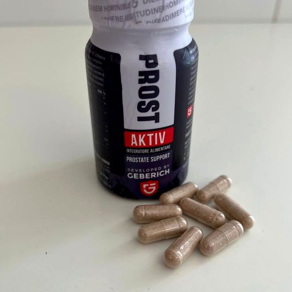 Barattolo scuro di ProstAktiv con le capsule beige accanto